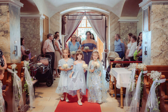 Kislányok vonulnak be a templomhajóba a hagyományos esküvői szertartás elején.